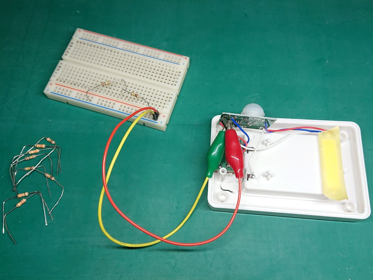 明暗センサーにワニ口クリップを挟み、ブレッドボードに抵抗器を付けて調整している写真